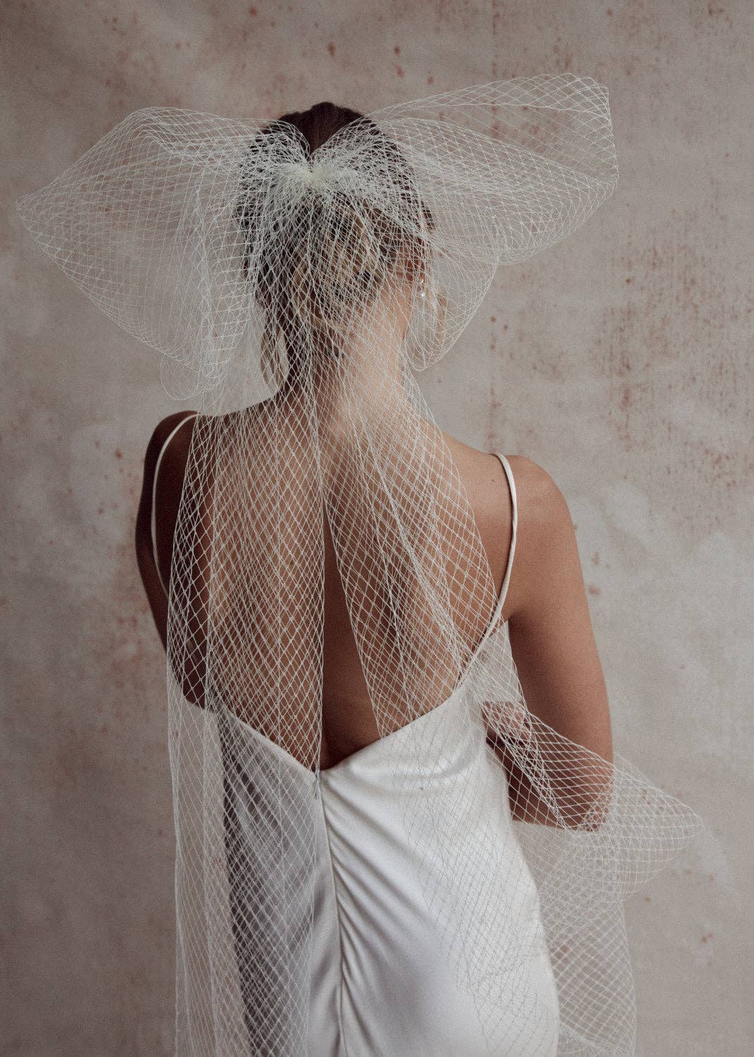 Bride wearing an oversized bow veil from net tulle