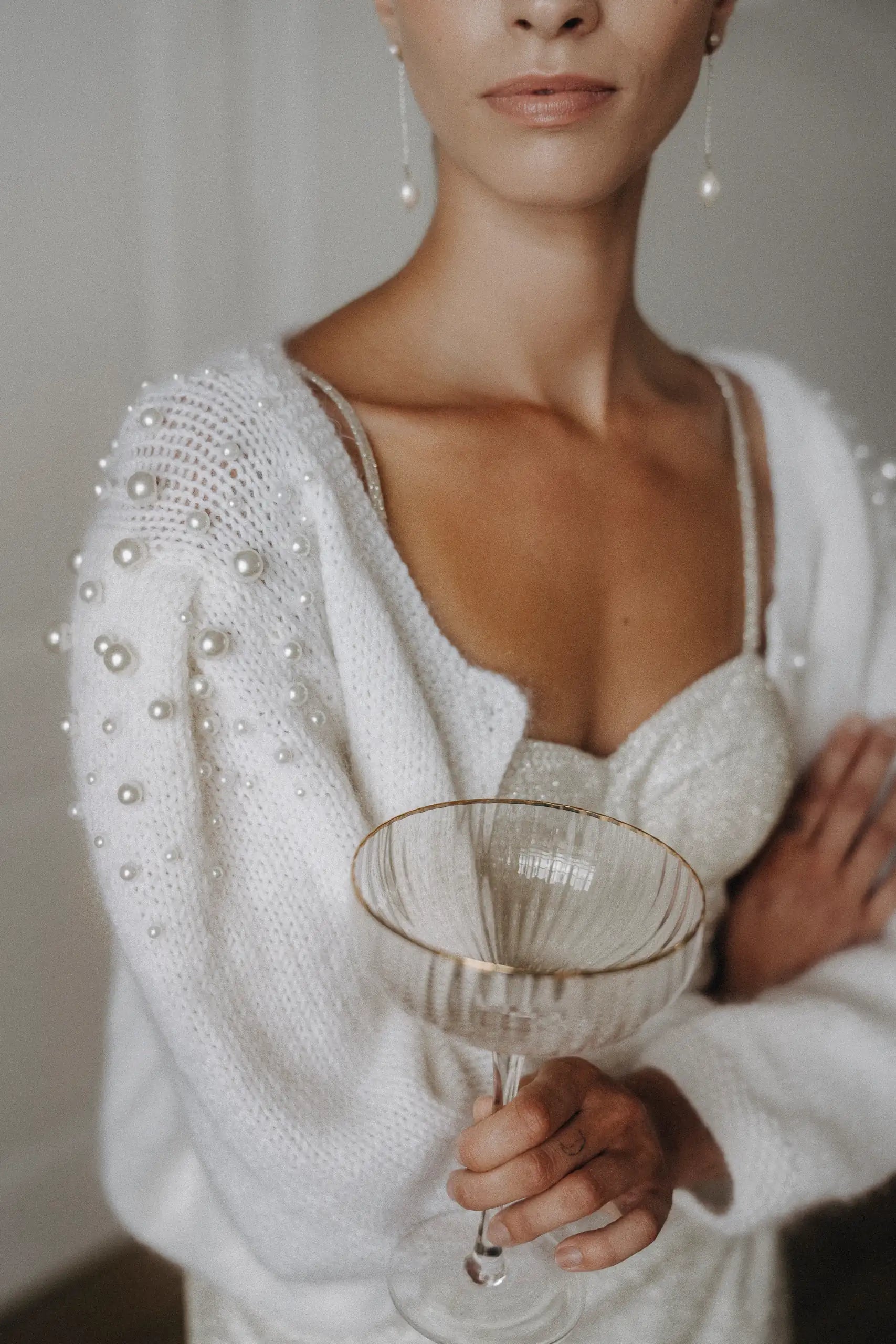 Taillenlange Braut Strickjacke mit weicher Silhouette und unterschiedlich Großen Perlen Details an der Schulterpartie
